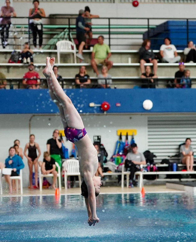 Diving athletes inside the water forming a geometric star formation.