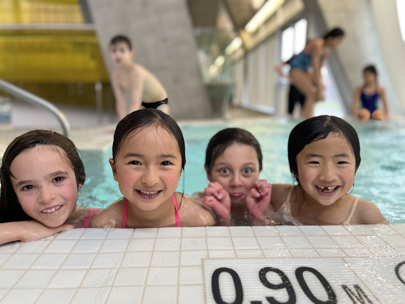 Children splashing inside a safe shallow training pool, getting comfortable with diving rules.